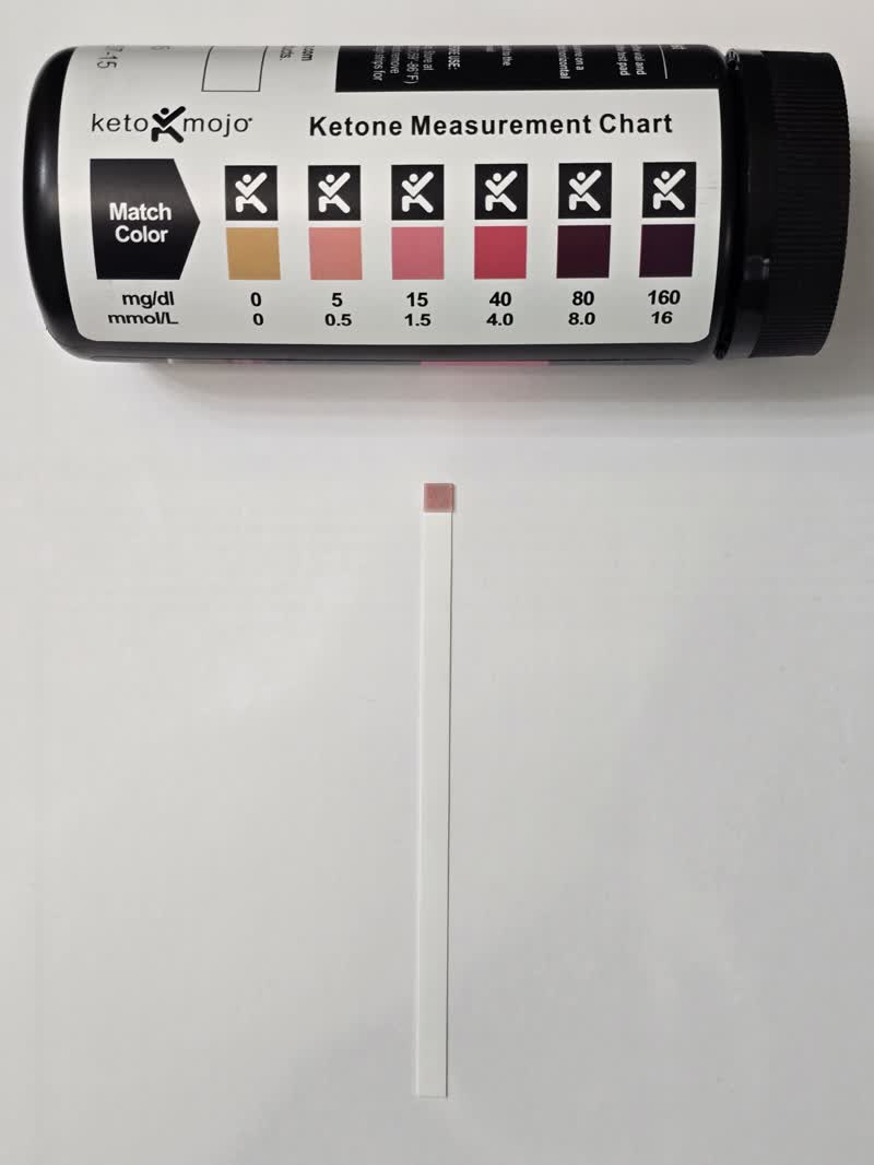 Day 37 ketone strip next to the color chart showing 1.5 mmol/L